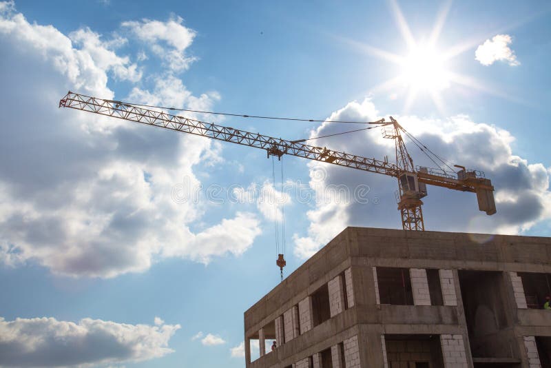 View of the construction crane in the construction of the house on a clear Sunny day, the backlight royalty free stock photography View of the construction crane in the construction of the house on a clear Sunny day, the backlight royalty free stock photography