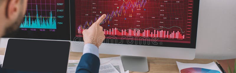 View of data analyst pointing on charts on computer monitor near laptop with blank screen on table, panoramic shot royalty free stock photos