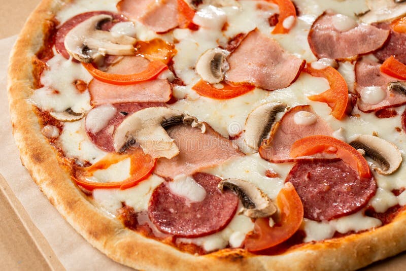 Top view of delicious Capricciosa Pizza on wooden table. Ingredients peeled tomato, cheese, ham, mushrooms, salami. stock photography Top view of delicious Capricciosa Pizza on wooden table. Ingredients peeled tomato, cheese, ham, mushrooms, salami. stock photography