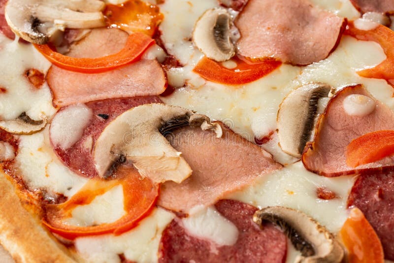 Top view of delicious Capricciosa Pizza on wooden table. Ingredients peeled tomato, cheese, ham, mushrooms, salami. royalty free stock image Top view of delicious Capricciosa Pizza on wooden table. Ingredients peeled tomato, cheese, ham, mushrooms, salami. royalty free stock image