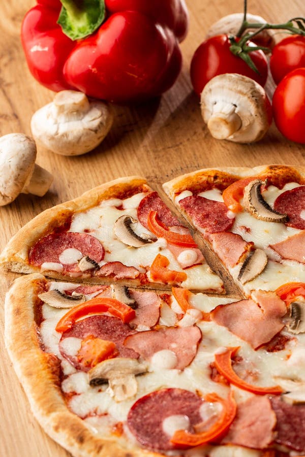 Top view of delicious Capricciosa Pizza on wooden table. Ingredients peeled tomato, cheese, ham, mushrooms, salami. stock images Top view of delicious Capricciosa Pizza on wooden table. Ingredients peeled tomato, cheese, ham, mushrooms, salami. stock images