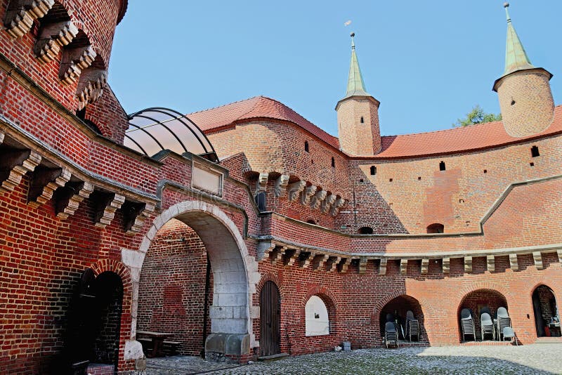 View of famous barbakan in Cracow, Poland. Courtyard. Part of the city wall fortification - old gate to Krakow. The best preserved popular medieval barbican in Europe. Travel, arhitectura concept. View of famous barbakan in Cracow, Poland. Courtyard. Part of the city wall fortification - old gate to Krakow. The best preserved popular medieval barbican in Europe. Travel, arhitectura concept.