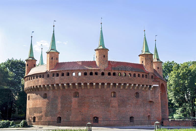 View of famous barbakan in Cracow, Poland. Part of the city wall fortification - old gate to Krakow. 15th century fortress - the best preserved popular medieval barbican in Europe. Travel, arhitectura concept. View of famous barbakan in Cracow, Poland. Part of the city wall fortification - old gate to Krakow. 15th century fortress - the best preserved popular medieval barbican in Europe. Travel, arhitectura concept.