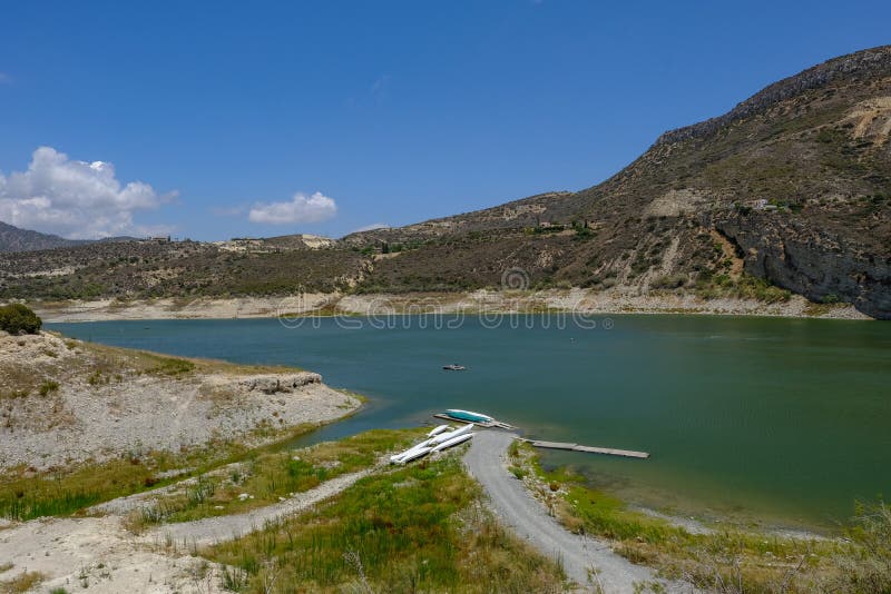 View of the germasogeia dam in Cyprus, taken on a bright blue sky day. Shot shows a path leading to canoes at the side of the