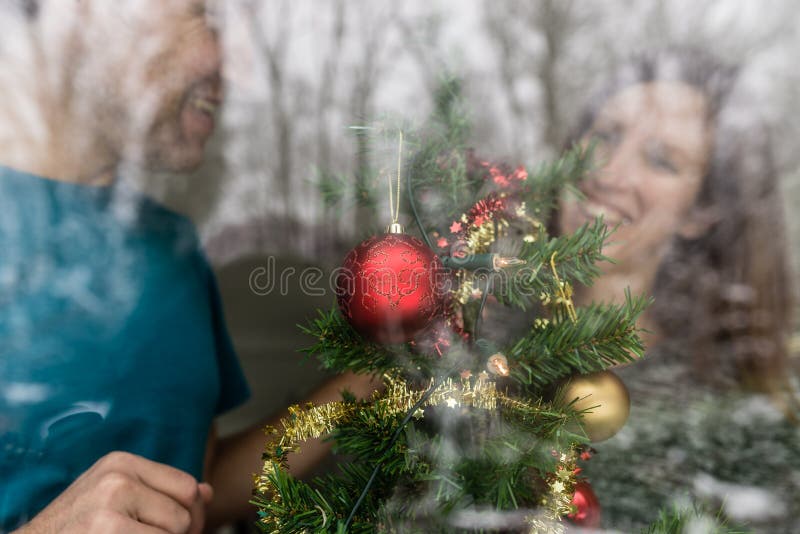 Happy young couple decorating Christmas tree stock image Happy young couple decorating Christmas tree stock image