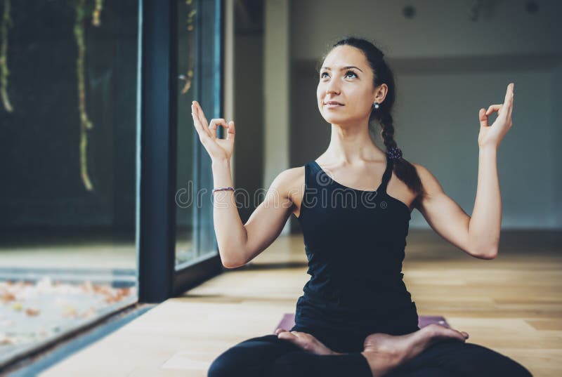 View of gorgeous young woman practicing yoga indoor. Beautiful girl practice ardha matsyendrasana in class.Calmness and