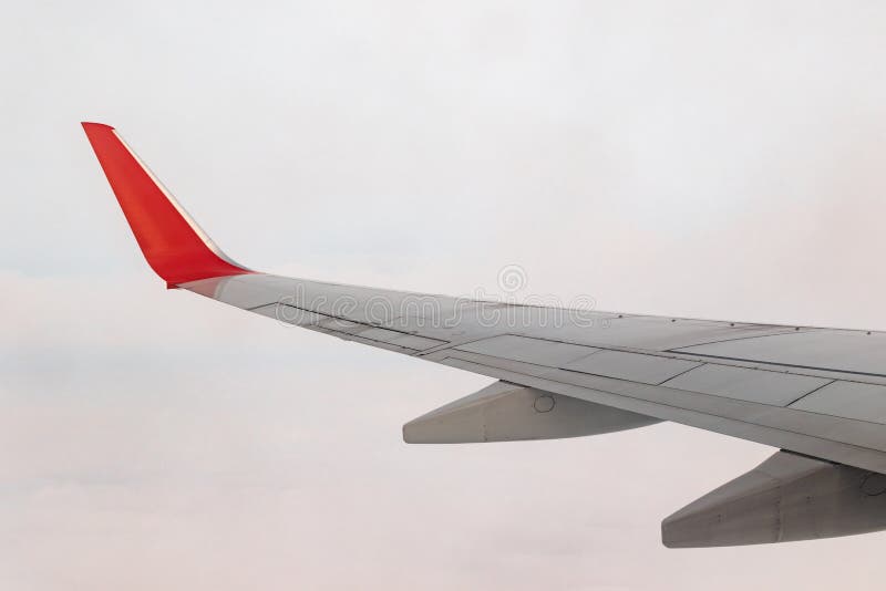 View of the gray sky from the height of flight above the clouds from the window of the plane in the bright sun. part of an airplane wing in the frame. Airplane height stock images, royalty-free photos and pictures