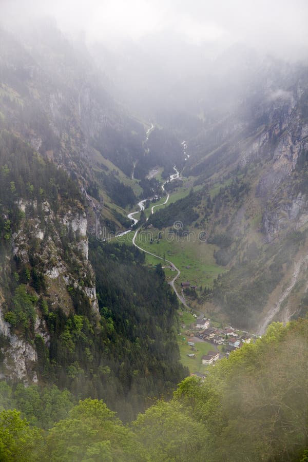 View On Green Alps Valley In Switzerland With Clouds And Foggy Weather