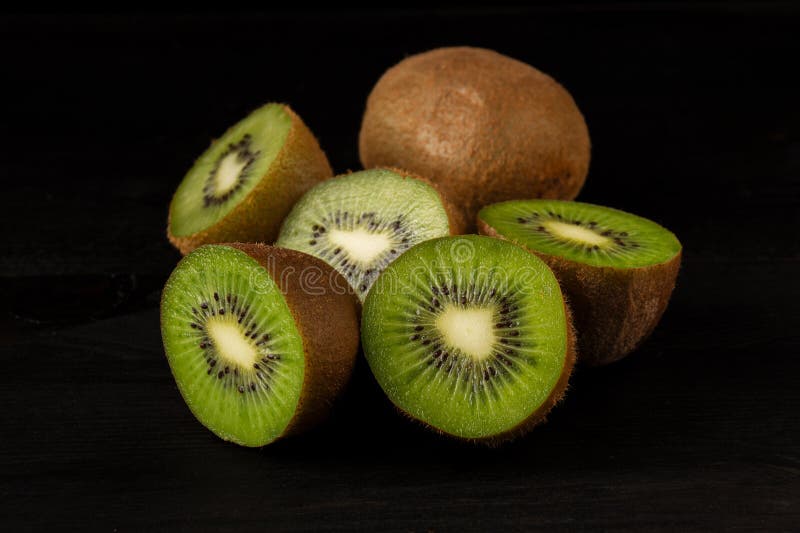 View of a group of open green kiwis on a black background, horizontally royalty free stock images