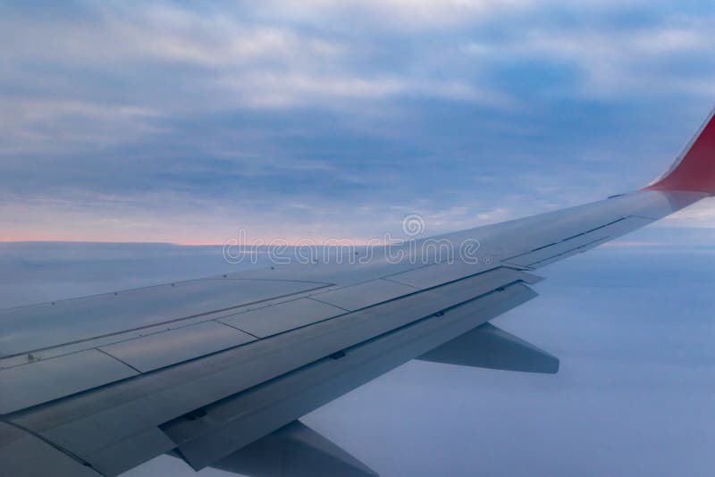 A view from a height above the clouds from the plane`s window. part of an airplane wing in the frame. Airplane height stock images, royalty-free photos and pictures