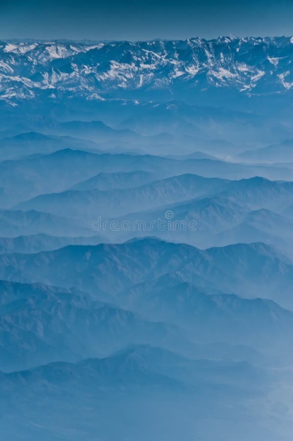 View from the height of the Himalayan mountains from an airplane in the early morning, a landscape in blue colors. blue mountains and foothills under us. Airplane height stock images, royalty-free photos and pictures