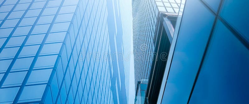 View of high rise glass building and dark steel window system on blue clear sky background, Common modern business skyscrapers.