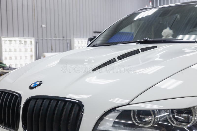 Вид на капот и решетку радиатора роскошного очень дорогого нового белого автомобиля BMW X6 M Lumma CLR tuning стоит в стиральной коробке и ждет. Новосибирск, Россия-08.01 роялти бесплатные стоковые фотографии