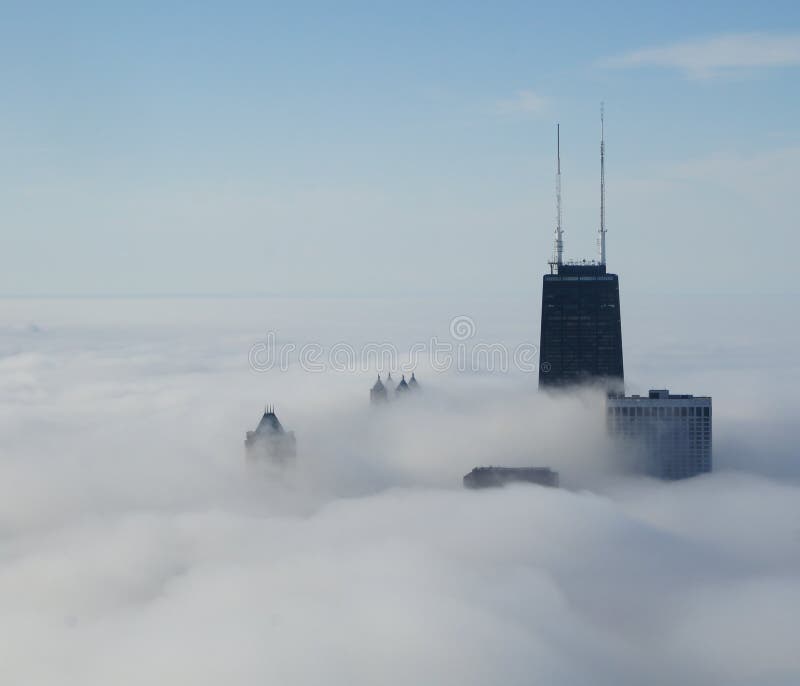 View of John Hancock Center and surrounding buildings above the clouds