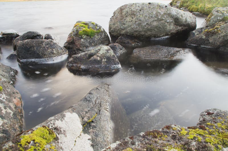 View Of The Large Stones Lying In The Water Of A Mountain Lake Stock