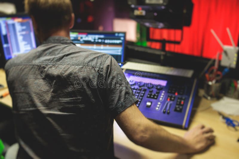 View of Lighting Technician Operator Working on Mixing Console