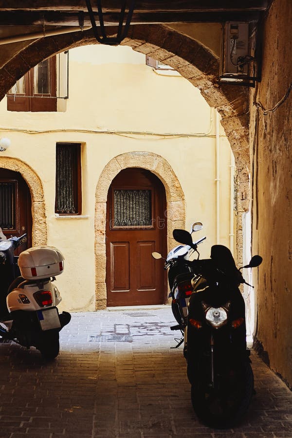 View of the narrow paved street and motorcycles in the traditional Greek town royalty free stock photos View of the narrow paved street and motorcycles in the traditional Greek town royalty free stock photos