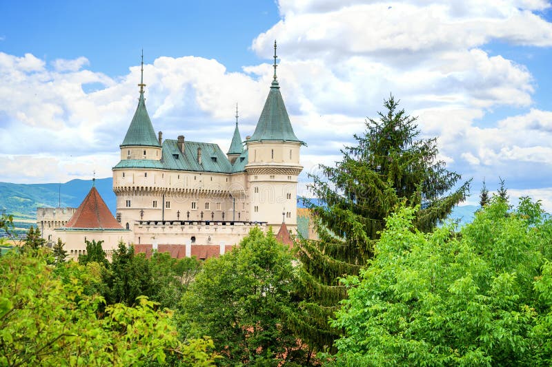 Pohled na novogotický Bojnický zámek přes koruny stromů Zámeckého parku Bojnice, Slovensko