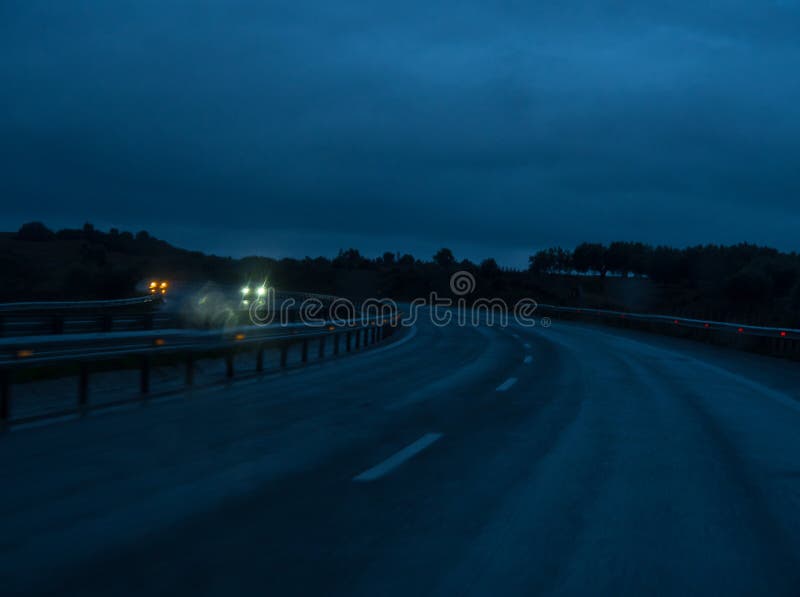 View of Night Highway through the Windshield of a Car at Speed in Rainy