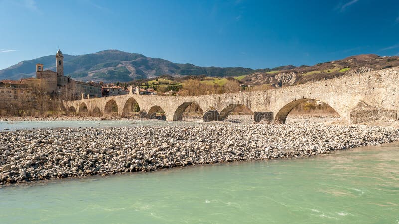 View of the old medieval bridge, called `Ponte del Diavolo` or `Ponte Gobbo` over the river Trebbia in the small town of Bobbio