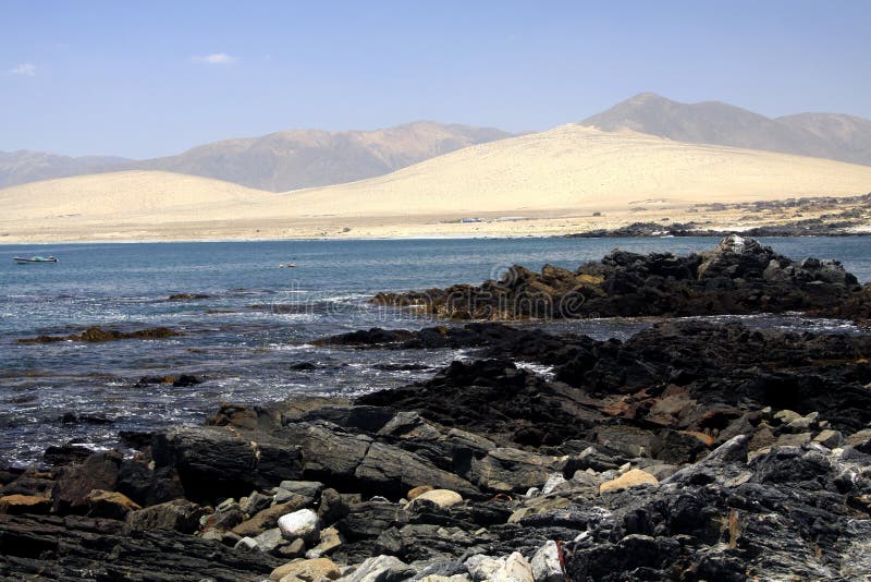 View over rugged stones and lonely lagoon on barren dry hills - Bahia Inglesa at pacific coast of Atacama desert royalty free stock photos View over rugged stones and lonely lagoon on barren dry hills - Bahia Inglesa at pacific coast of Atacama desert royalty free stock photos
