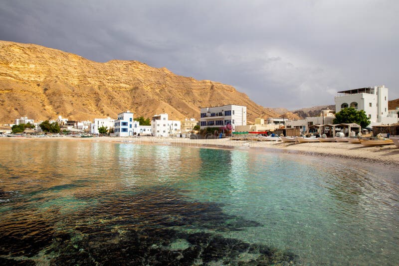 View of picturesque village of Quantab on the coast of Gulf of Oman. Fishing boats on the sandy beach