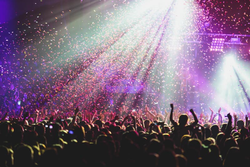 Pohled na rock koncert ve velký koncertní sál, s davem a fázi světla, přeplněný koncertní sál s scéna, světla, rock show výkon, s lidé silueta.