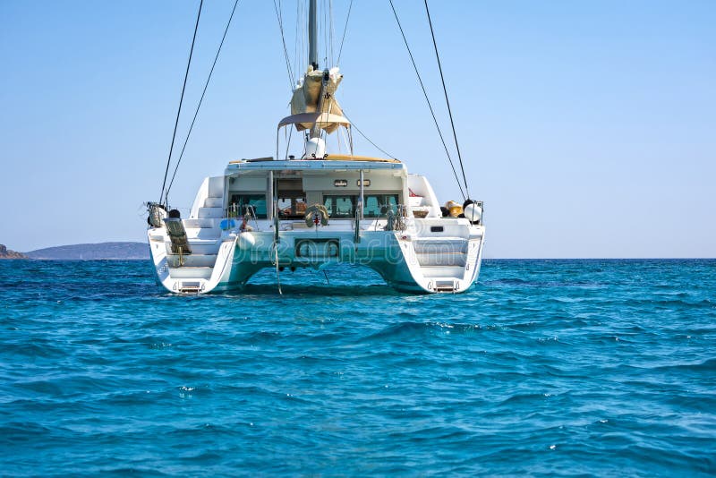 Sailing catamaran in blue waters of the Aegean sea.