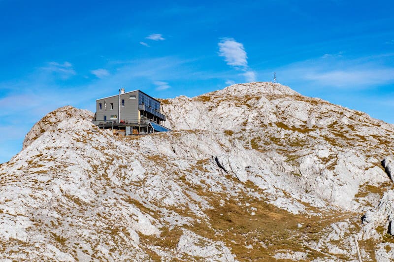 View of the Schiestlhaus mountain hut refugio on top of the Hochschwab moutain, sunny weather, sunset, blue sky. Autumn vibes in