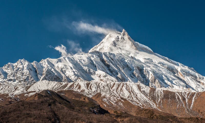 View of snow covered peak of Mount Manaslu 8 156 meters with clouds in Himalayas, sunny day at Manaslu Glacier in Gorkha, Nepal