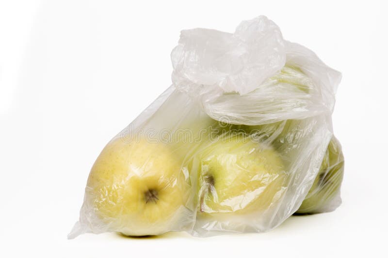 View of some yellow apples inside a plastic bag.