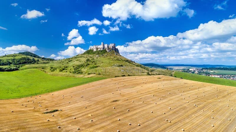 View of Spissky hrad and a field with round bales in Slovakia