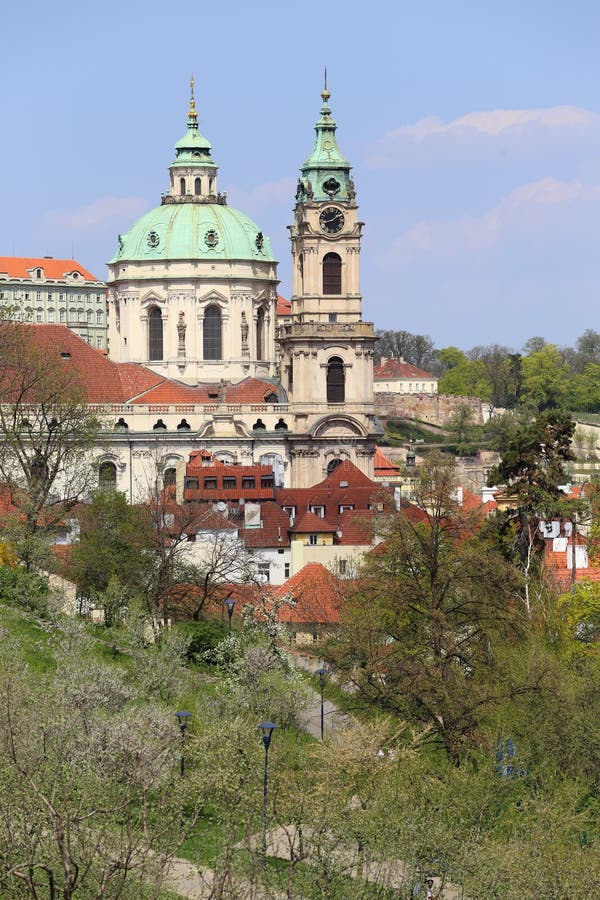 View on the spring Prague St. Nicholas' Cathedral with the green Nature and flowering Trees, Czech Republic