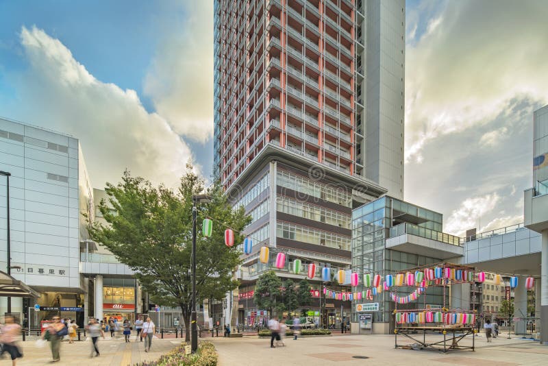 View of the square in front of the Nippori train station decorated for the Obon festival in the sunset summer sky.