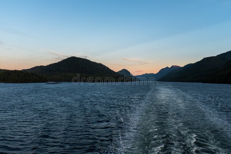 The view at sunset from the back of a ferry as it makes its way through the Inside Passage off the rugged west coast of Canada, royalty free stock photography The view at sunset from the back of a ferry as it makes its way through the Inside Passage off the rugged west coast of Canada, royalty free stock photography