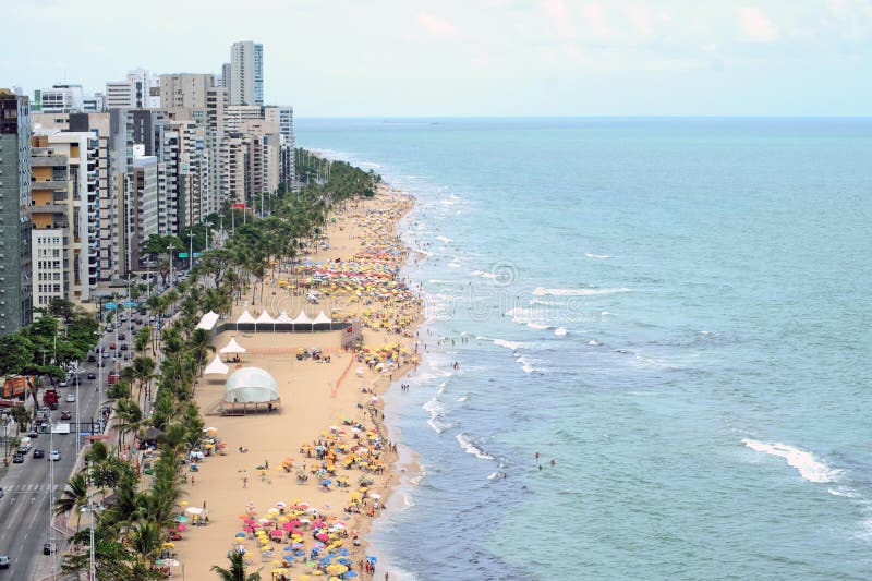 A view to the city beach with lots of Brazilian people sunbathing and swimming, a view from the top of a skyscraper.