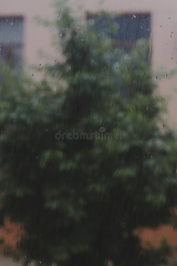 View to raining weather through the home window. Raindrops on the window glass. Heavy raining outdoors. Spring rain season royalty free stock photo View to raining weather through the home window. Raindrops on the window glass. Heavy raining outdoors. Spring rain season royalty free stock photo