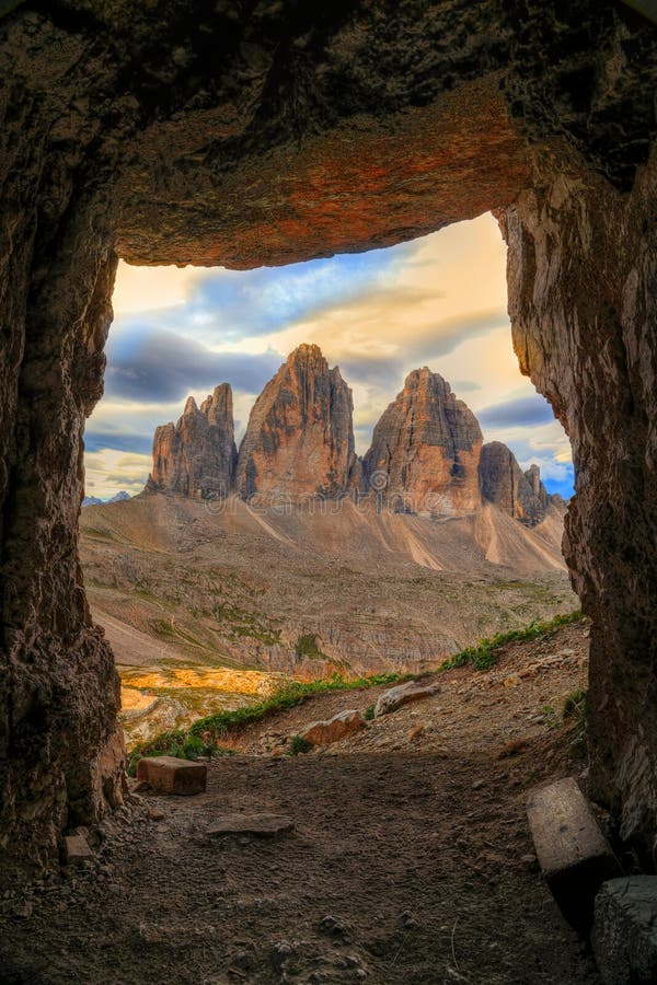 View to Tre Cime di Lavaredo in sunrise time from a cave