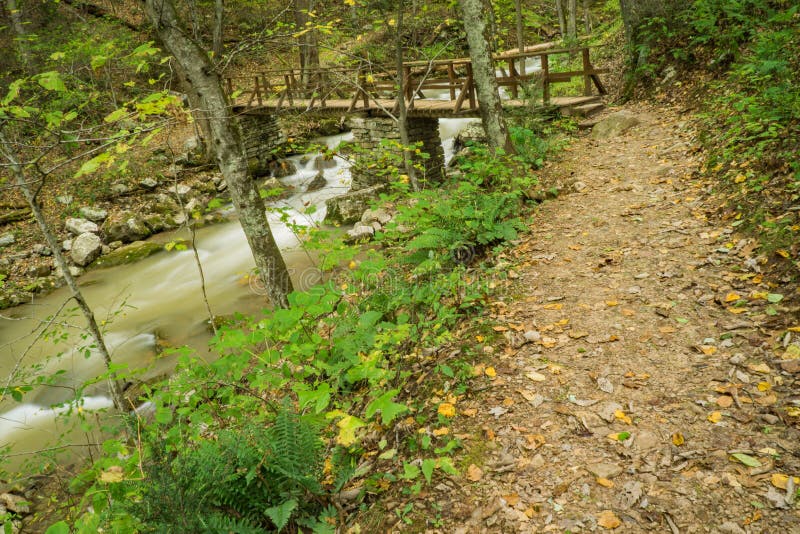 View of Trail, Bridge and Creek at Roaring Run Recreational Area. An autumn view of a hiking trail, bridge and Roaring Run Creek at Roaring Run Recreational Area royalty free stock images View of Trail, Bridge and Creek at Roaring Run Recreational Area. An autumn view of a hiking trail, bridge and Roaring Run Creek at Roaring Run Recreational Area royalty free stock images