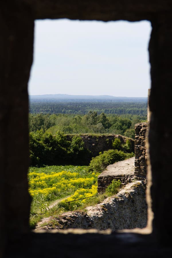 View through the window in the wall of a ruined stone fortress Koporye