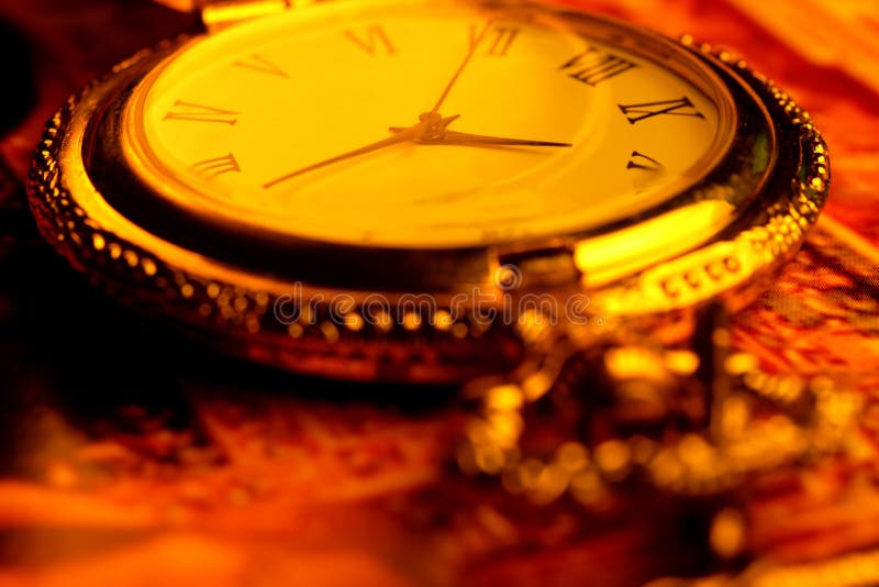 Golden antique watch in golden background. Golden antique watch in golden background