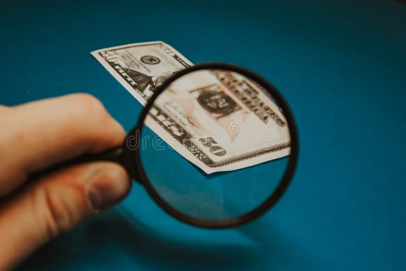 Vijftig dollarrekening op een blauwe achtergrond die door een vergrootglas worden bestudeerd royalty-vrije stock foto's Vijftig dollarrekening op een blauwe achtergrond die door een vergrootglas worden bestudeerd royalty-vrije stock foto's