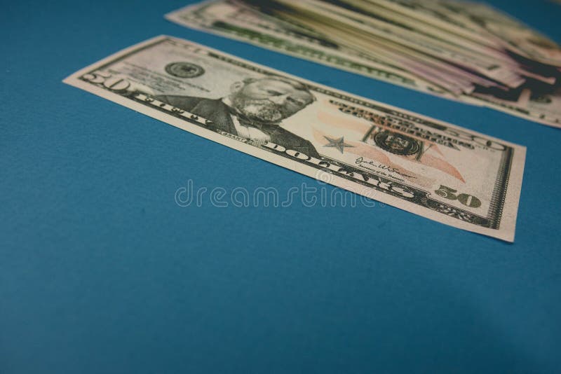 Vijftig dollarrekening op een blauwe achtergrond die door een vergrootglas worden bestudeerd royalty-vrije stock afbeelding Vijftig dollarrekening op een blauwe achtergrond die door een vergrootglas worden bestudeerd royalty-vrije stock afbeelding