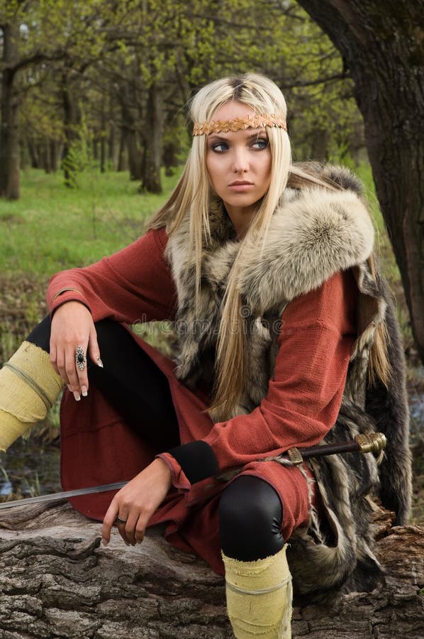 Viking girl with sword in a wood