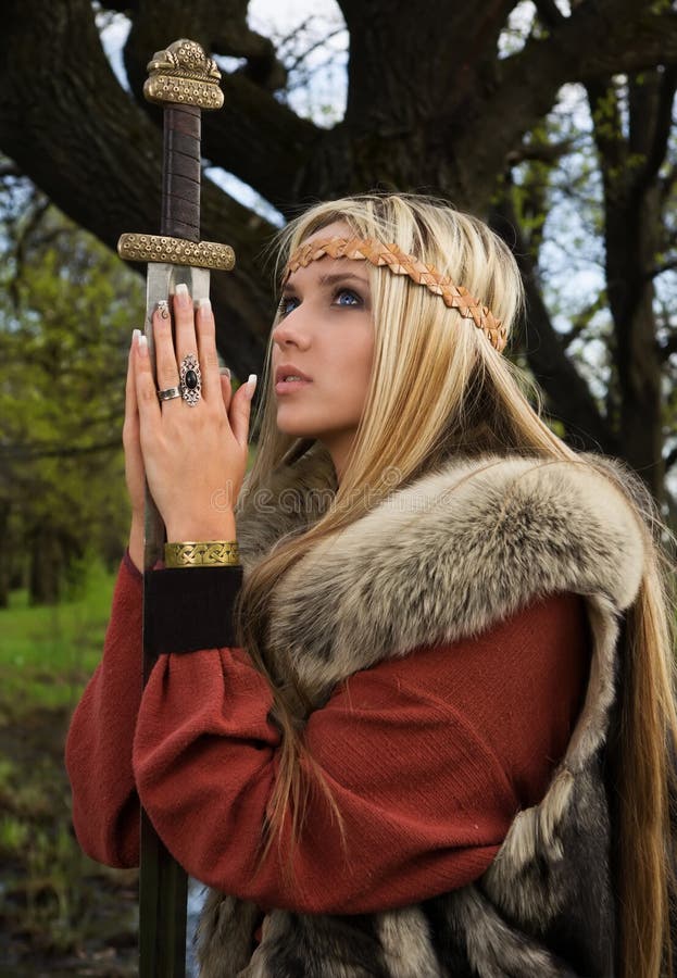 Viking girl with sword in a wood