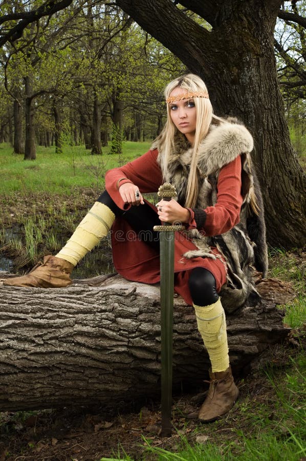 Viking girl with sword in a wood