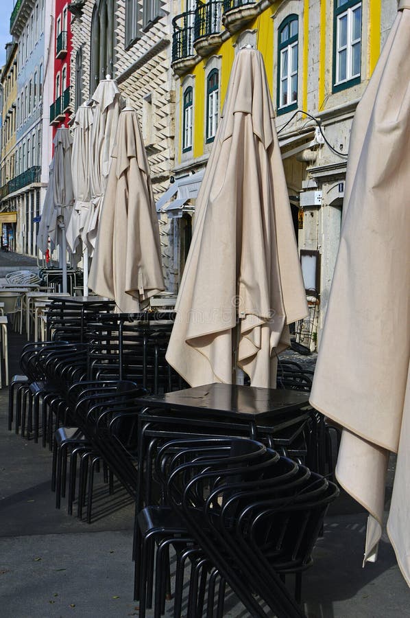 Vikta paraplyer, stolar och tabeller av restaurangen royaltyfria foton Vikta paraplyer, stolar och tabeller av restaurangen royaltyfria foton