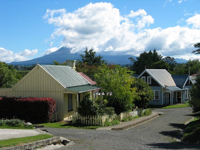 Early Settlers' Village, Stratford, New Zealand. The extinct volcano Taranaki (Mt Egmont) is in the background partially covered in cloud. Early Settlers' Village, Stratford, New Zealand. The extinct volcano Taranaki (Mt Egmont) is in the background partially covered in cloud.