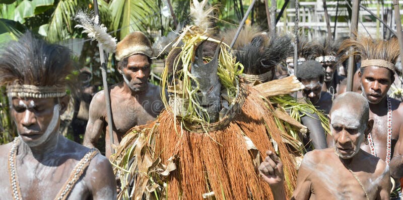 YOUW VILLAGE, ATSY DISTRICT, ASMAT, NEW GUINEA, INDONESIA - MAY 23: The Village follows the ancestors embodied in spirit mask as they tour the village. Jjungle of New Guinea.Indonesia. May 23, 2016. YOUW VILLAGE, ATSY DISTRICT, ASMAT, NEW GUINEA, INDONESIA - MAY 23: The Village follows the ancestors embodied in spirit mask as they tour the village. Jjungle of New Guinea.Indonesia. May 23, 2016