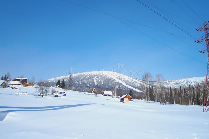 Village bloqué par la neige au pied de gamme de montagne images libres de droits Village bloqué par la neige au pied de gamme de montagne images libres de droits
